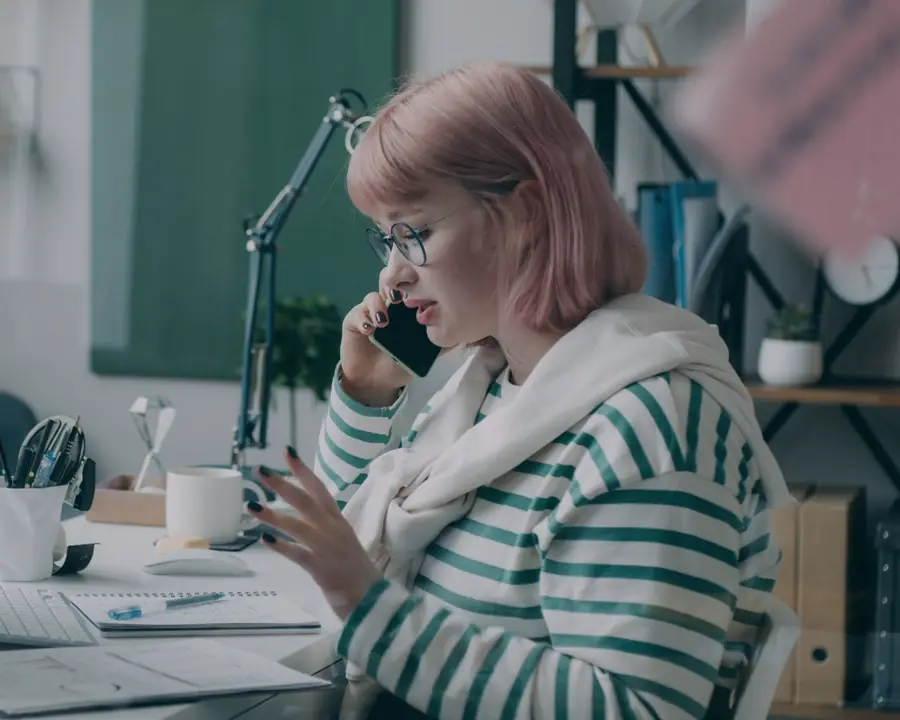 A commercial real estate professional on a phone call at her desk, working through paperwork.